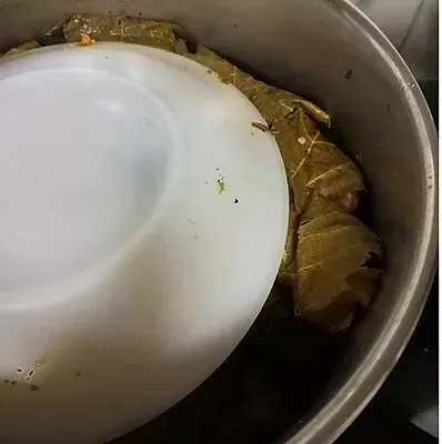 Koupepia packed into the pot under a plate