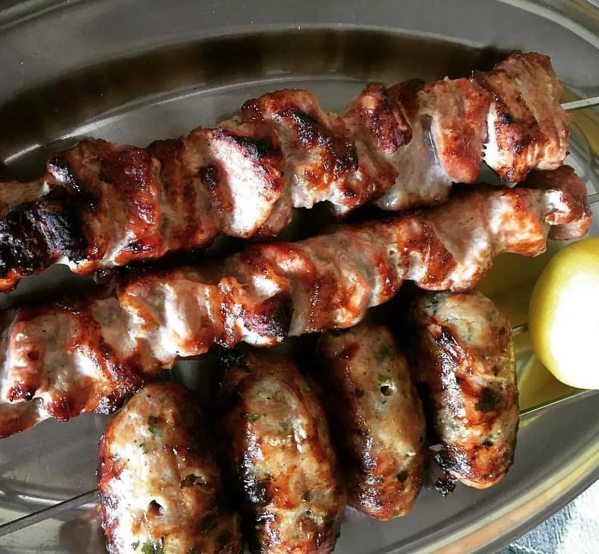 Sheftalia grilling over charcoal